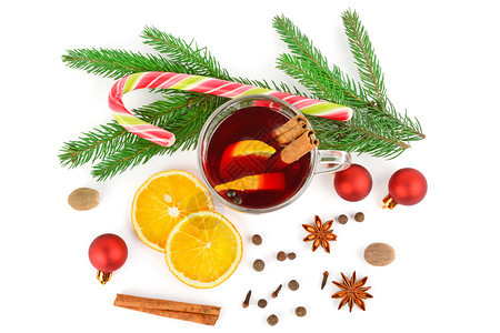 白色背景的热红味葡萄酒与圣诞香料橙片蚂蚁和肉桂棒隔绝图片