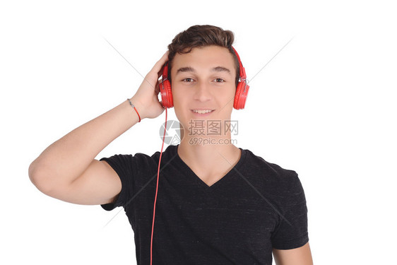 带耳机的笑青少年听音乐的肖像孤立白色背景图片