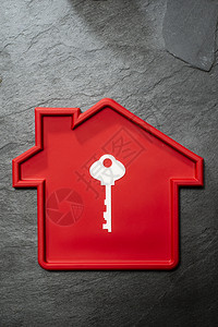 红房子形状和白钥匙住房建筑概念地产暗石背景和自然硬光图片