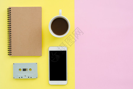 办公桌工作空间平的办公空间白笔记本盒式磁带咖啡杯和糊面背景的模拟电话粉色背景空间概念图片