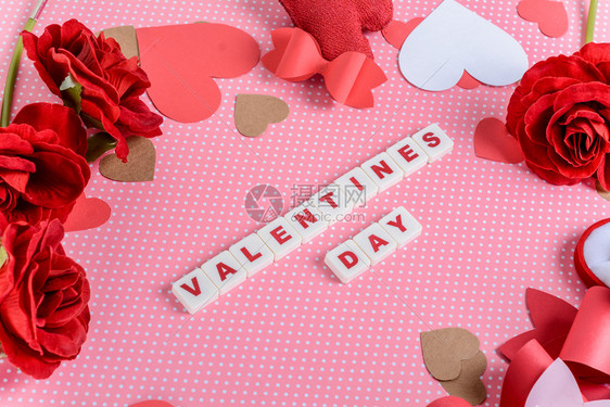 有情人节装饰的背景和短语情人节由粉色背景上的字母立方体制成图片