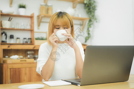 坐在家中的起居室喝着热咖啡在家享受时间图片