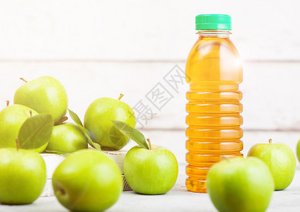 瓶装新鲜有机苹果汁绿盒装在木背景上有阳光的文本空间图片