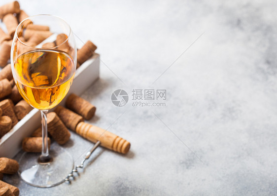 玻璃白葡萄酒装有软木箱和叉子开瓶器放在石厨桌背景上顶部视图图片