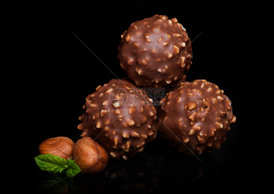 黑色大理石底有桃子片和薄荷叶的豪华巧克力糖果图片