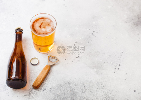 和玻璃瓶手工艺啤酒开瓶器在石头厨房餐桌背景图片