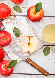 一杯新鲜的有机苹果汁粉红色的苹果放在木制的砍板上图片