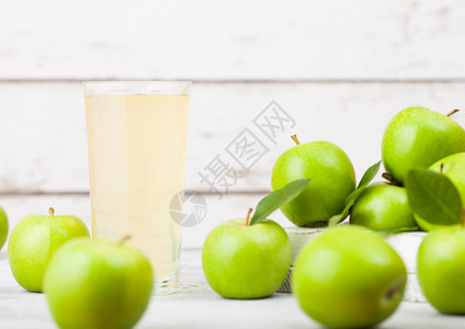 玻璃杯新鲜有机苹果汁在木本底盒中装有健康的绿苹果文本空间图片