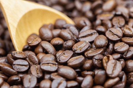 咖啡豆质地或背景棕色烤咖啡豆和木勺背景图片