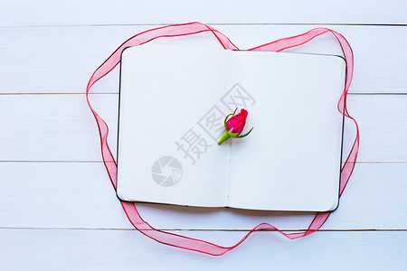 白木背景上带玫瑰和丝的日记笔本顶部视图情人节day的概念图片