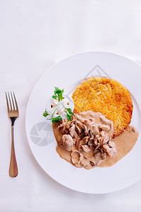 奶油蘑菇肉汁酱和炸的罗索薯当地菜白盘图片