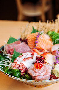 在手工艺陶瓷碗中紧地拍下手工艺陶瓷碗中的日本新鲜洋葱金鱼沙西米阿托罗塔科鲑鱼大马奇和沙比图片