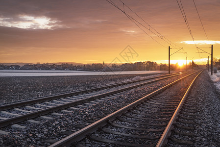 在日出时铁路德意志乡村和雪田的轨道上运行冬季旅概念火车运输基础设施图片