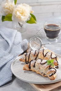 新鲜的法国羊角面包和咖啡紧贴在羊角面包上图片