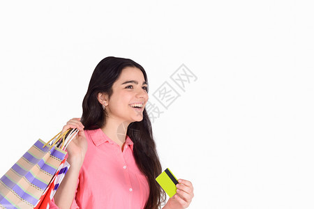 拥有购物袋和信用卡购物销售概念孤立白种背景的年轻美女图片
