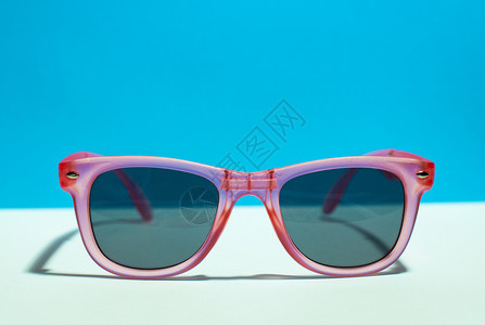 粉红色明太阳镜蓝面纱背景夏天时间派对和假期概念墨镜的最小图片