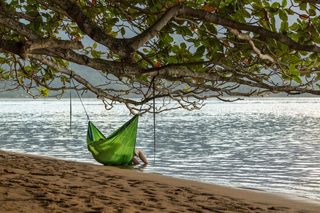 情侣睡在海边的睡袋上图片