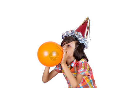 小男孩的肖像充气橙球并戴着党帽庆祝的概念图片