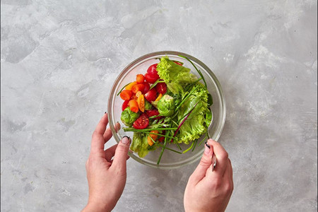 女用天然有机蔬菜和绿奶酪橄榄油烹饪素食沙拉用玻璃碗和白板上的新鲜沙拉停止运动画用有机天然蔬菜绿色橄榄油制作健康的素食沙拉图片