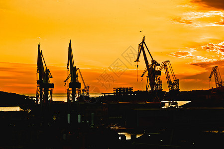 普拉镇造船厂起重机日落剪影视图克罗地亚伊斯特里亚地区图片
