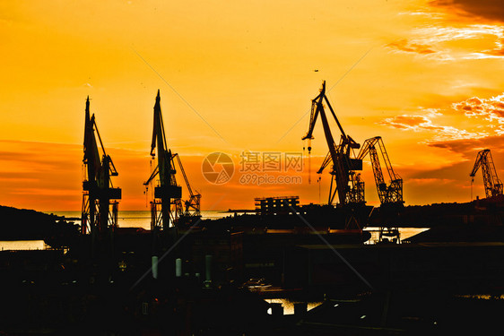 普拉镇造船厂起重机日落剪影视图克罗地亚伊斯特里亚地区图片