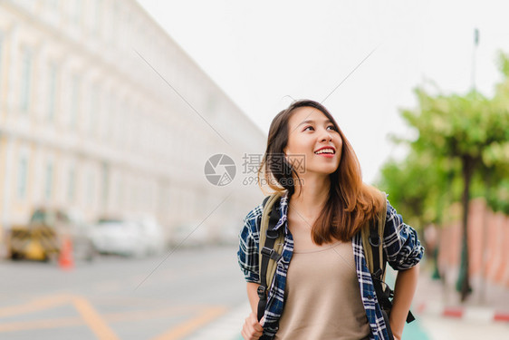 快乐的年轻女在惊人的地标度假享受传统城市的旅程图片