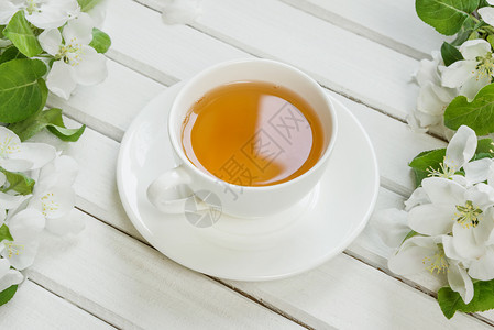 一杯绿茶和苹果树花用白色的木本底图片