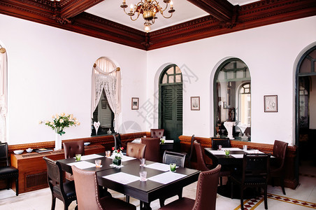 2014年3月7日BangkoThailnd内地古老房子有黑色旧式餐桌皮椅橄榄绿木门和天花板上的经典灯图片