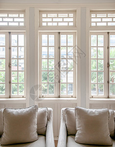 白色殖民古老的客厅有扶椅和典型最起码设计枕头窗户有自然光的舒适房间图片