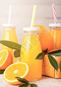 有机新鲜橙汁玻璃瓶浅木底带生橙子图片