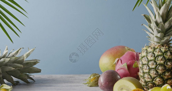 香味水果椰子和芒棕榈叶放在灰色木桌上蓝素食者健康概念运动4k视频3840216p各种多汁的异国水果蓝色的灰木桌上莱切菠萝和卡兰波图片