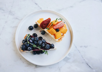 美味的蓝莓馅饼和芒果在白大理石桌背景自制面包风格上加草莓薄饼图片