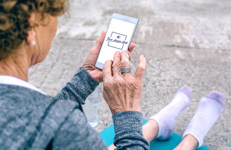 在海上码头使用智能手机的无法识别老年妇女后视线可定制的移动屏幕使用智能手机的老年妇女后视线图片