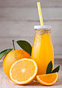 玻璃瓶有机新鲜橙汁浅木底带生橙子图片