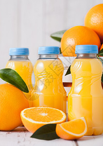 白色木箱中含生橙子的有机新鲜汁小塑料瓶图片