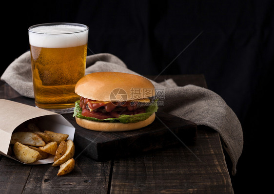 新鲜牛肉汉堡配土豆饼和木本底啤酒杯图片