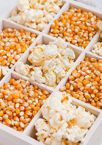 鲜金甜玉米种子和白木盒中的爆米花图片