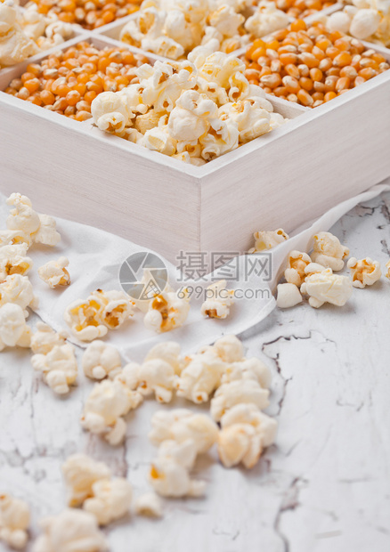 浅底白木盒中的鲜金甜玉米种子和爆花图片