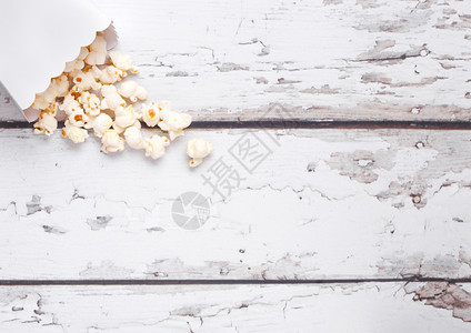 木制背景上鲜盐爆米花的纸箱图片