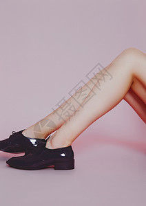 穿着粉红背景的闪亮鞋子美丽时装模特腿图片