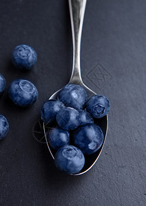 黑石厨房板上的旧勺子蓝莓天然健康食物生命摄影图片