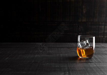 玻璃威士忌和木制背景的冰块图片