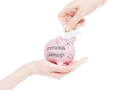 女手握着有个人储蓄概念的猪银行用文字手把硬币放入白背景图片