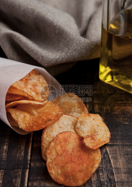 土豆薯片和木板上的橄榄油垃圾食品图片