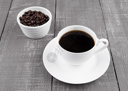 黑咖啡杯早餐用黑咖啡豆子在木制背景上图片