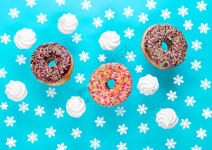 蓝底早餐用蛋白和雪花的巧克力甜圈图片
