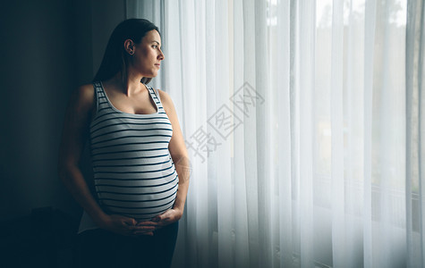在卧室抚摸肚子的孕妇图片
