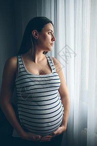 在卧室抚摸肚子的孕妇图片