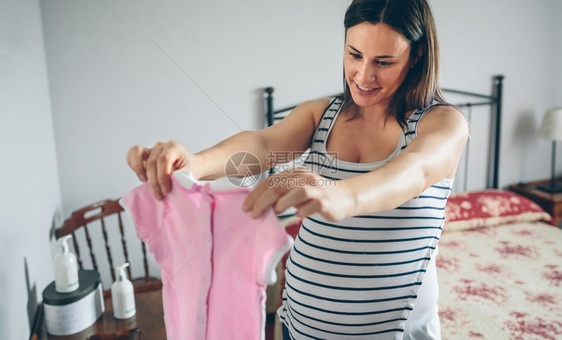 有选择地以妇女为背景重点怀孕时着女婴服装图片