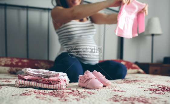 孕妇为婴儿选择衣服图片